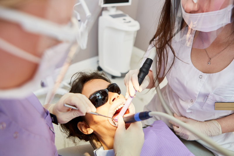 Lekarz endodonta wraz z asystą wykonują precyzyjne leczenie kanałowe w gabinecie SmileUp w Warszawie